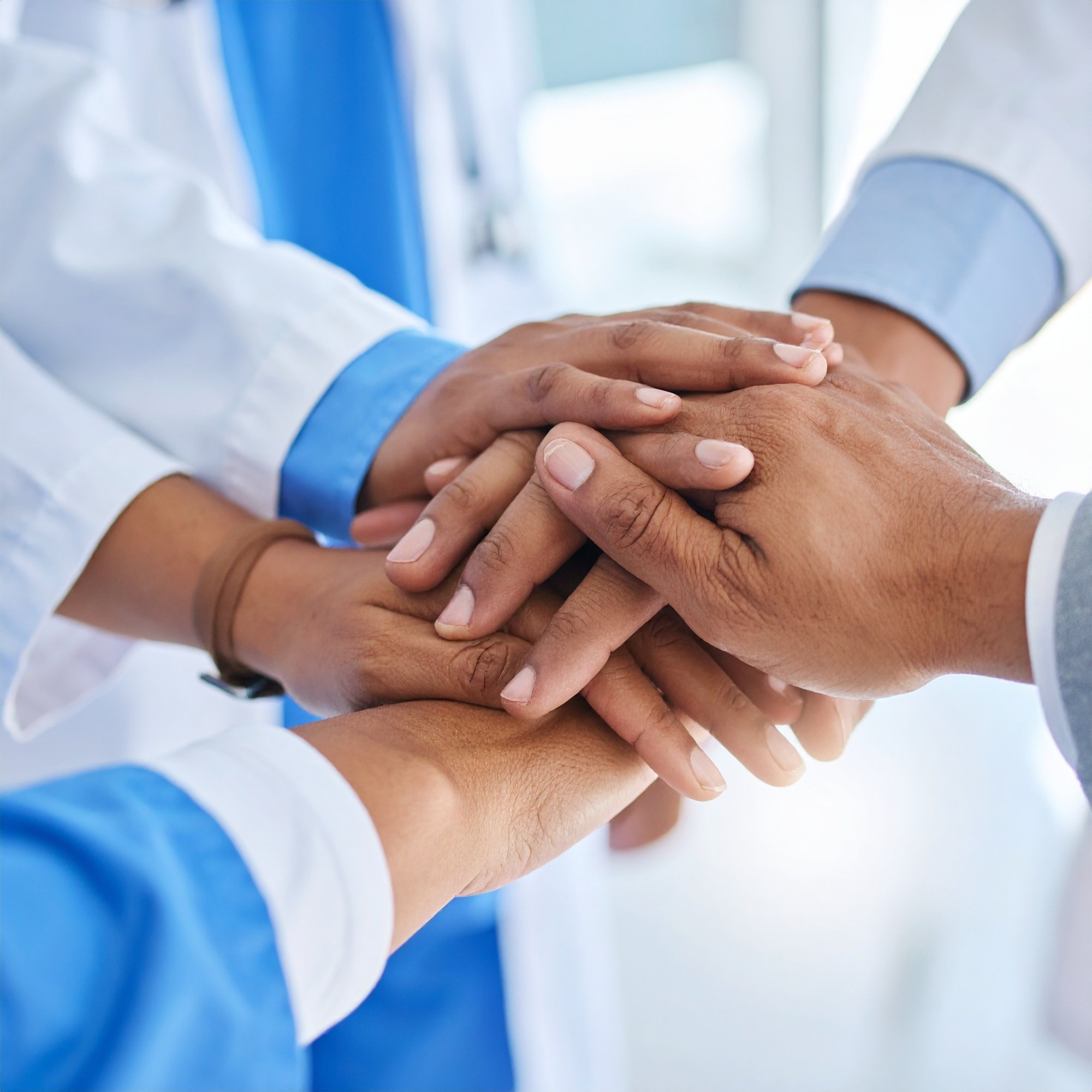 Firefly_Four hands stacked together in a hospital environment- one patient wearing a hospital 166493